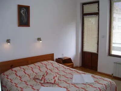 a bedroom with a bed with a red and white blanket at Rahoff hotel in Bansko