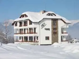 a white house with snow on top of it at Rahoff hotel in Bansko
