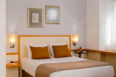 a bedroom with a large bed with orange pillows at Arte Sofia Hotel in Sofia