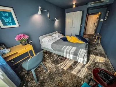 a bedroom with a bed and a desk and a chair at Hotel Rila in Dupnitsa