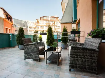 a patio with chairs and tables on a balcony at Bright House in Plovdiv