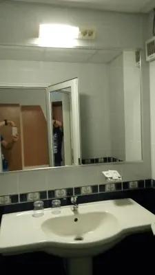 a bathroom with a sink and a mirror at Panorama Hotel in Sandanski