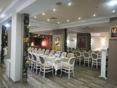a banquet hall with white tables and white chairs at Panorama Hotel in Sandanski