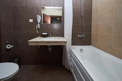 a bathroom with a sink and a tub and a toilet at Mountain Paradise next to Sunrise in Bansko