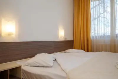 a bedroom with a white bed and a window at Mountain Paradise next to Sunrise in Bansko