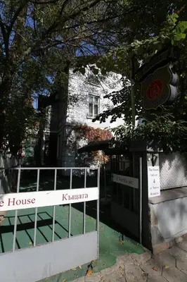 a white fence in front of a house at Hotel & Restaurant The House in Sofia