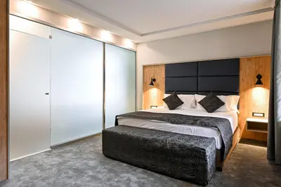 a bedroom with a large bed with a large headboard at Grand Hotel Velingrad in Velingrad