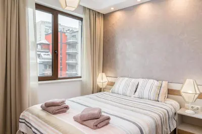 a bedroom with a bed with two towels on it at M&M Modern & Multifunctional One Bedroom Apartment by Flat Mаnager in Sofia