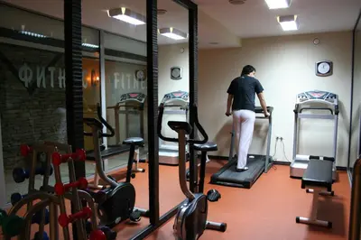 a man standing on a treadmill in a gym at Hotel Bansko SPA & Holidays - Free Parking in Bansko