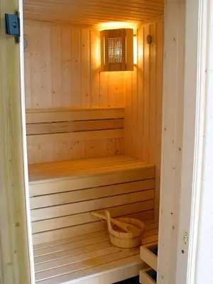 a small wooden sauna with a basket in it at Dafovska Hotel in Pamporovo