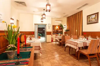 a restaurant with tables and chairs in a room at The Stream Resort Pamporovo in Pamporovo