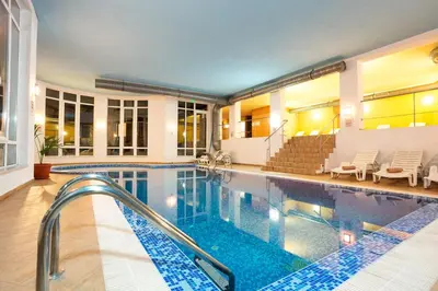 a swimming pool with chairs and a swimming pool at The Stream Resort Pamporovo in Pamporovo