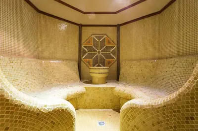 a tiled bathroom with two benches and a toilet at The Stream Resort Pamporovo in Pamporovo