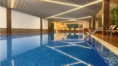 a large swimming pool in a building with a pool at Platinum Hotel and Casino Bansko in Bansko