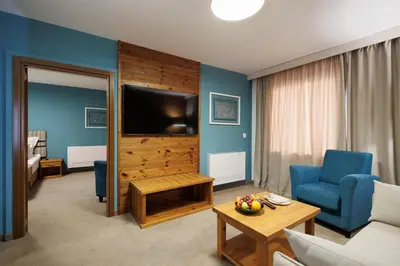 a living room with a tv and a couch and a table at Katarino SPA Hotel in Bansko