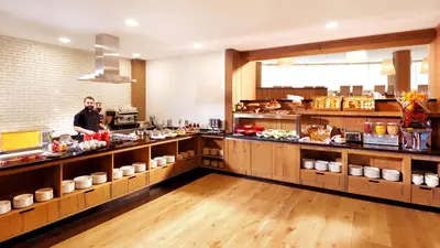 a man standing behind the counter of a kitchen at Metropolitan Hotel Sofia, a member of Radisson Individuals in Sofia
