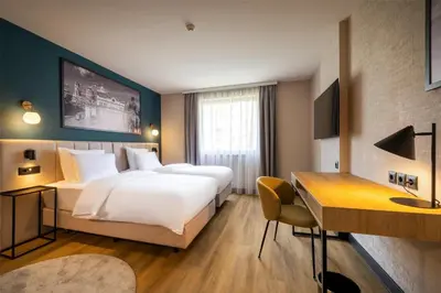 a hotel room with two beds and a desk at Metropolitan Hotel Sofia, a member of Radisson Individuals in Sofia