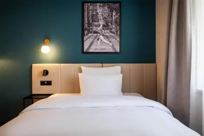 a bedroom with a white bed and a green wall at Metropolitan Hotel Sofia, a member of Radisson Individuals in Sofia