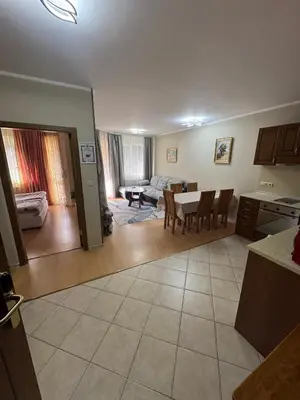 a kitchen and living room with a table and chairs at Royal Plaza Apartments Borovets in Borovets