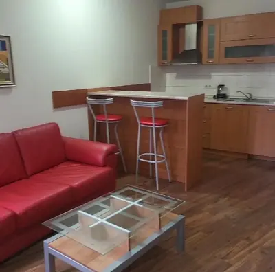 a living room with a red couch and a kitchen at Royal Plaza Apartments Borovets in Borovets