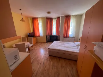 a small room with a bed and some windows at Royal Plaza Apartments Borovets in Borovets