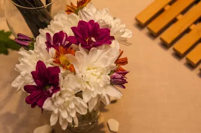 a vase filled with white and purple flowers on a table at Triada Hotel in Sofia