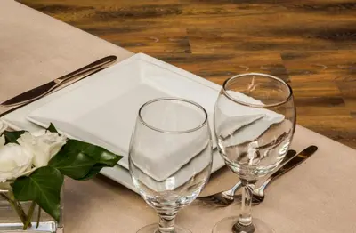two wine glasses sitting on top of a table at Triada Hotel in Sofia