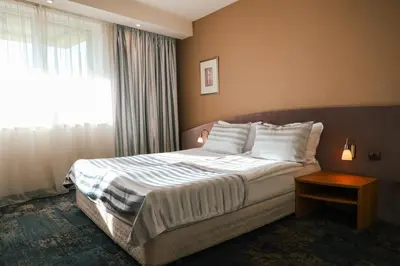 a hotel room with a bed and a window at Triada Hotel in Sofia