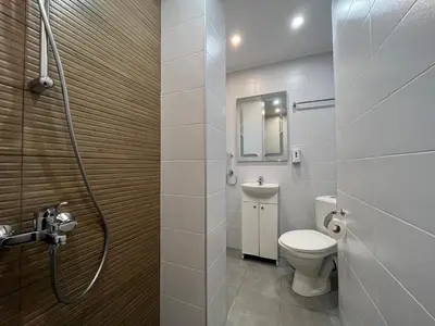 a bathroom with a toilet and a sink and a shower at Horizont Dobrinishte in Dobrinishte