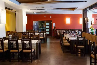 a dining room with tables and chairs and red walls at Sunrise Park Hotel Bansko - Free Wellness in Bansko