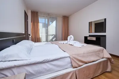 a bedroom with a large bed with a towel on it at Sunrise Park Hotel Bansko - Free Wellness in Bansko