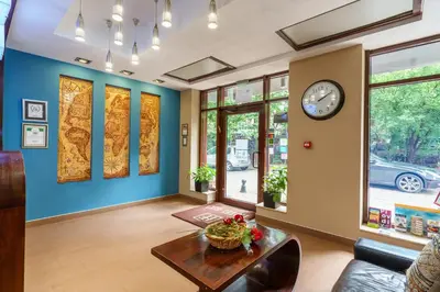 a living room with a clock on the wall and a table at Hotel Ego - Free Parking - Top Central Location in Plovdiv