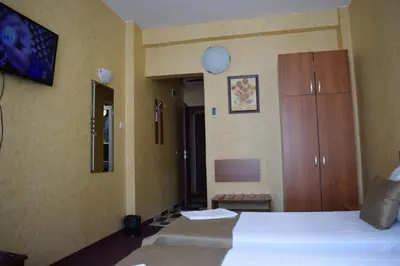 a hotel room with two beds and a cabinet at Slavyanska Beseda Hotel in Sofia