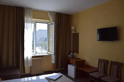 a hotel room with a television and a window at Slavyanska Beseda Hotel in Sofia
