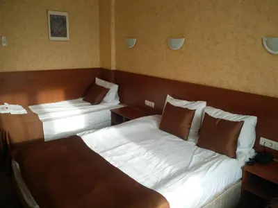 a hotel room with two beds and two tables at Slavyanska Beseda Hotel in Sofia