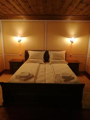 a bedroom with a large bed with two lights on it at Once upon a time in Koprivshtitsa