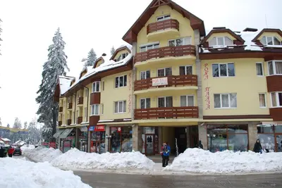 a large building with snow in front of it at PM Services Royal Plaza Apartments in Borovets