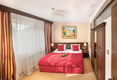 a hotel room with a red bed and a window at Hotel Yastrebets Wellness & Spa in Borovets