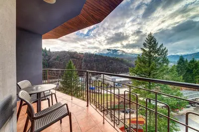 a balcony with a table and chairs and a view at SPA Hotel Kiparis in Smolyan