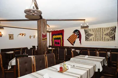 a dining room with tables and chairs with white table cloth at Forest Nook Aparthotel in Pamporovo