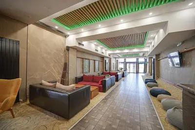 a waiting area with couches and chairs in a lobby at Riverside Boutique Hotel in Bansko