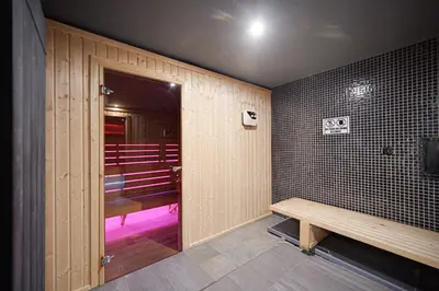 a bathroom with a bench and a door with a room at Riverside Boutique Hotel in Bansko