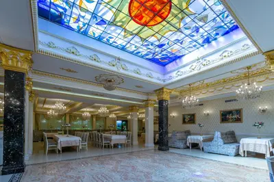 a lobby with a stained glass ceiling and tables and chairs at Hotel Montecito in Sofia