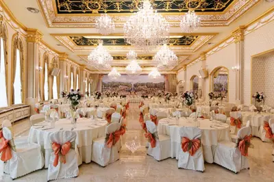 a large banquet hall with white tables and chandeliers at Hotel Montecito in Sofia