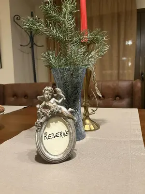a table with a vase and a clock on a table at Hotel Smilen in Smolyan