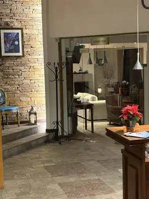 a living room with a brick wall and a window at Hotel Smilen in Smolyan