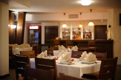 a dining room with tables and chairs with white table cloth at Hotel Smilen in Smolyan