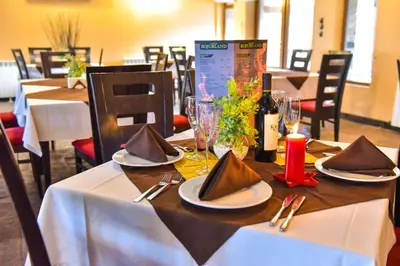 a table with plates and napkins on top at Hotel Bojur & Bojurland Apartment Complex in Bansko