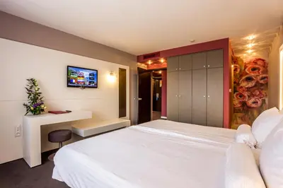 a bedroom with a large white bed and a desk at Grand Hotel Plovdiv in Plovdiv