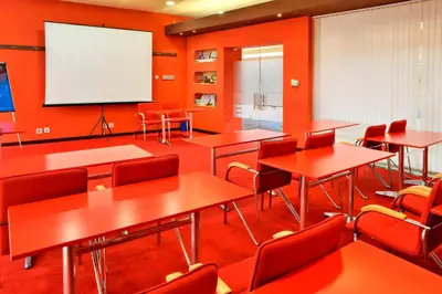 a classroom with tables and chairs and a screen at Grand Hotel Plovdiv in Plovdiv